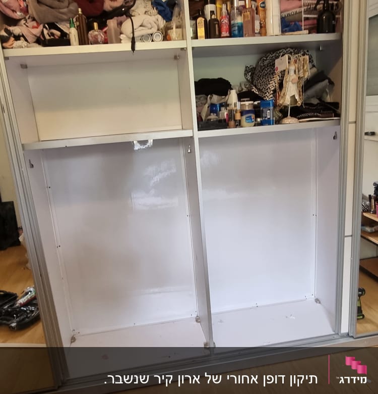 ארון פתוח עם כלים לתיקון על הרצפה